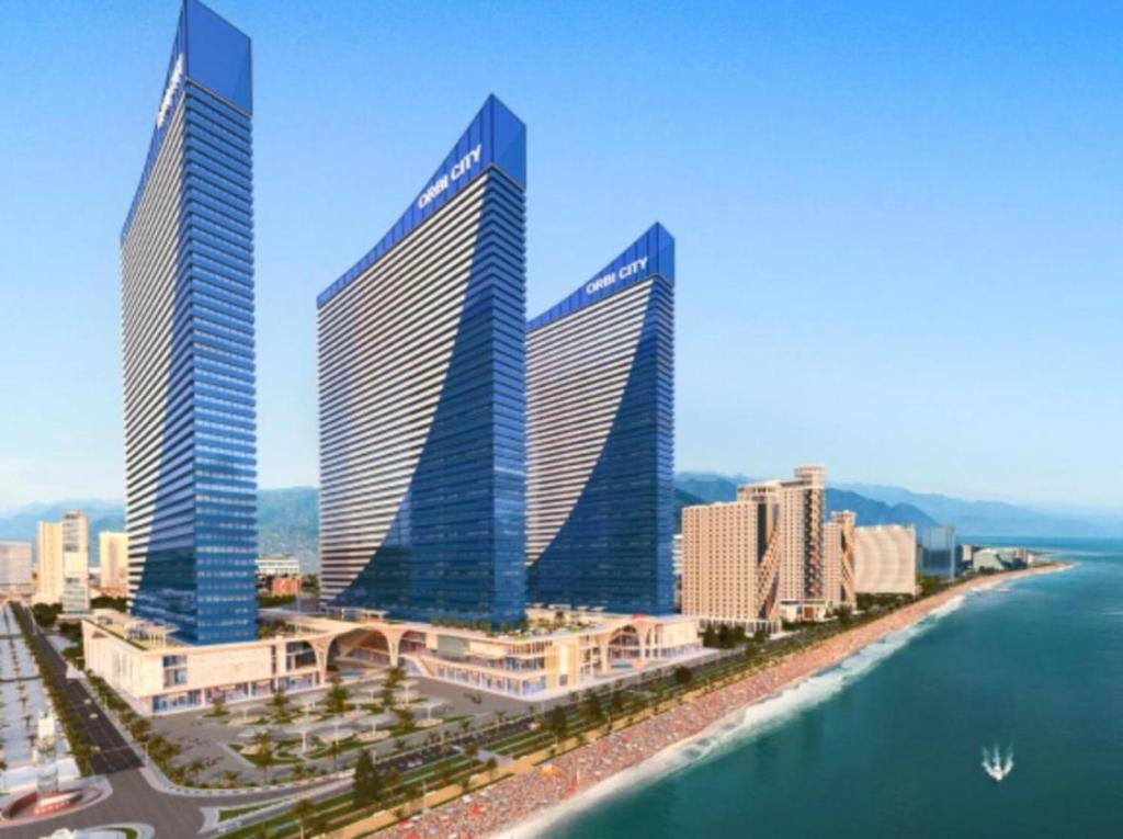 three tall buildings in a city next to the water at Sea views apartments In Batumi in Batumi