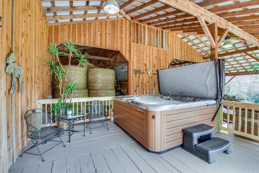 a large outdoor deck with a hot tub and chairs at Converted Barn Couple's Oasis Near Tallulah Gorge in Clarkesville