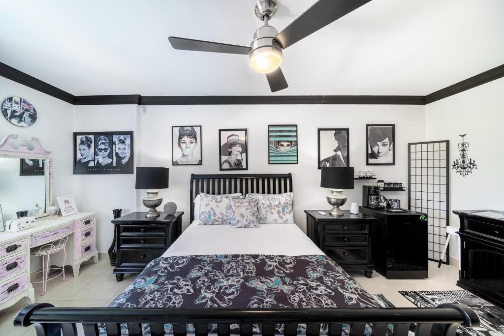 a bedroom with a bed and a sink and pictures on the walls at Hidden Gem Barbados in Christ Church