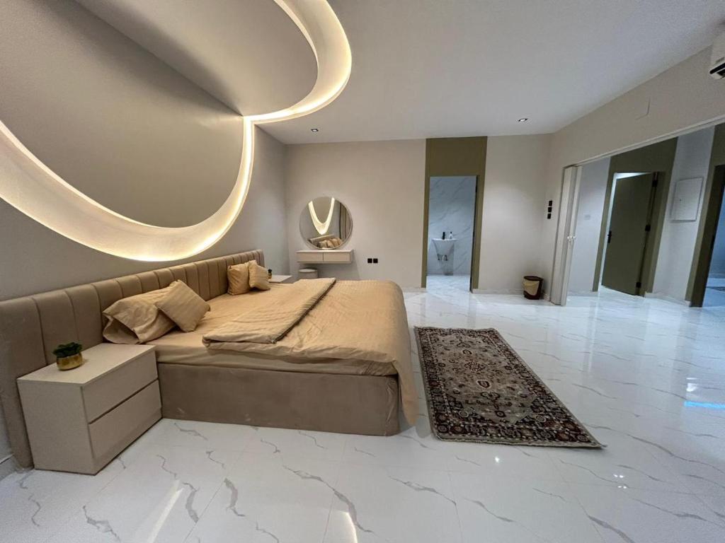 1 dormitorio con 1 cama grande y espejo grande en HAFAL Resort شاليهات هافال, en Riad