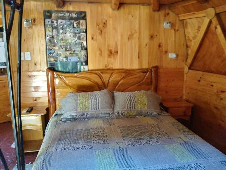 1 dormitorio con 1 cama con cabecero de madera en ammonite aventura del Maipo casa entera reserva 50 por ciento anticipado, en San José de Maipo