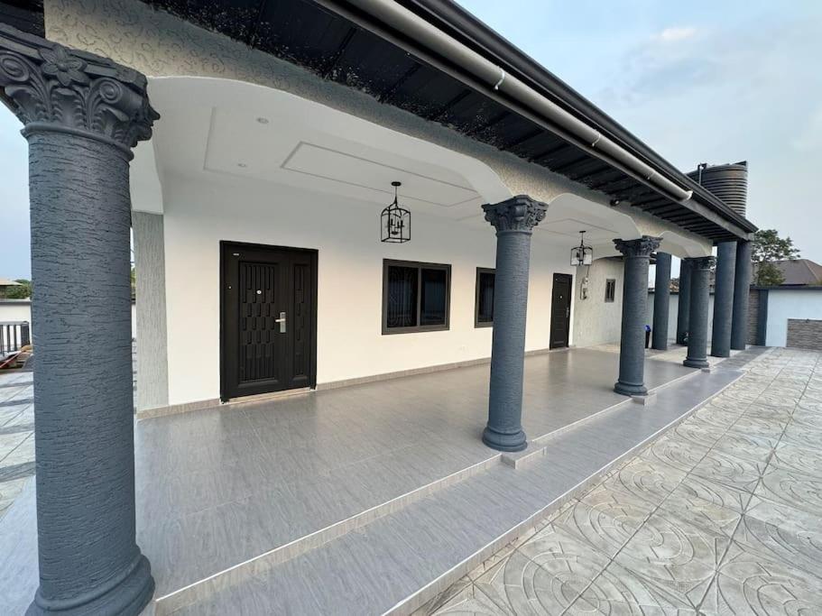 eine Reihe von Säulen an der Außenseite eines Gebäudes in der Unterkunft Calm Luxurious Home in Ejisu