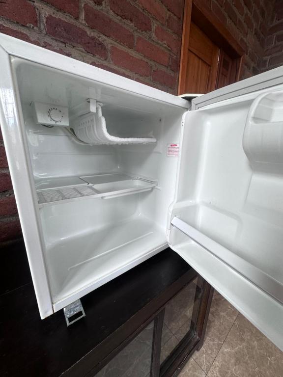 um frigorífico vazio com a porta aberta numa cozinha em Baños De Agua Santa em Baños