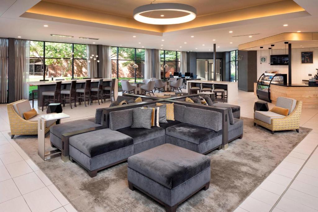 a living room with couches and chairs and a bar at Delta Hotels by Marriott Minneapolis Northeast in Minneapolis