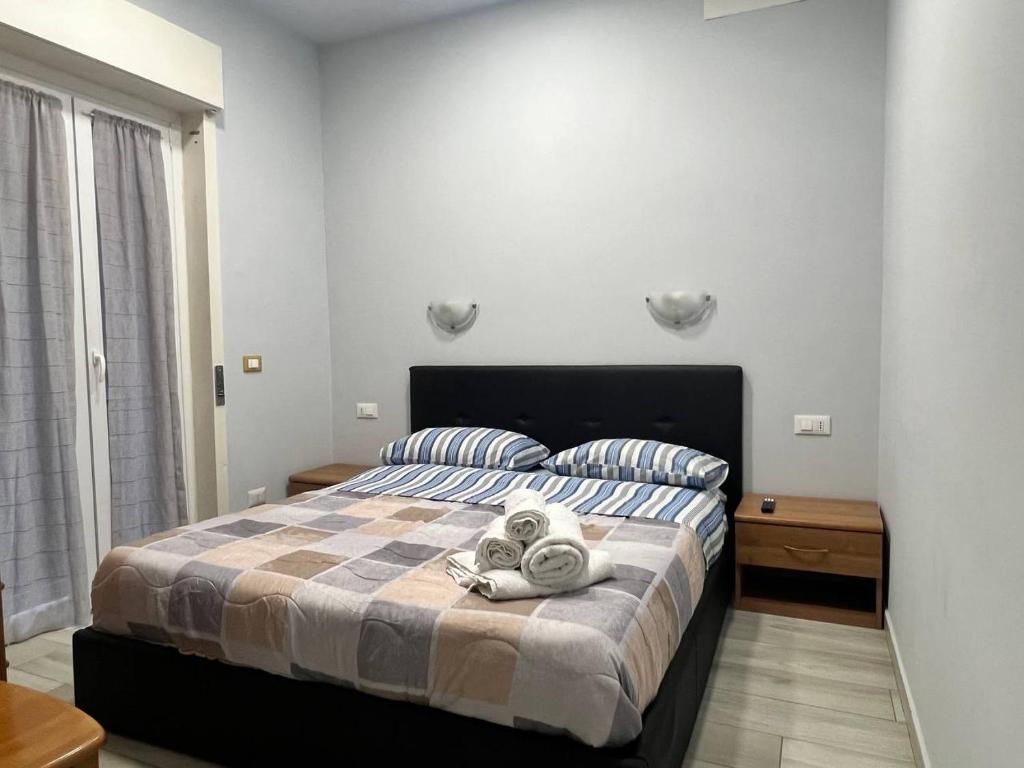 una camera da letto con un letto e asciugamani di MyHouse 4 - Centro Sicilia Aeroporto Humanitas a Catania