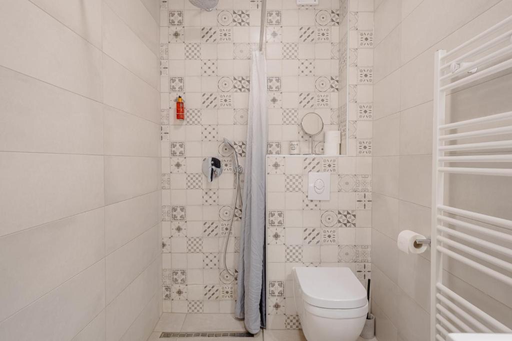 a white bathroom with a toilet and a shower at Rogač Rooms & Restaurant in Omiš