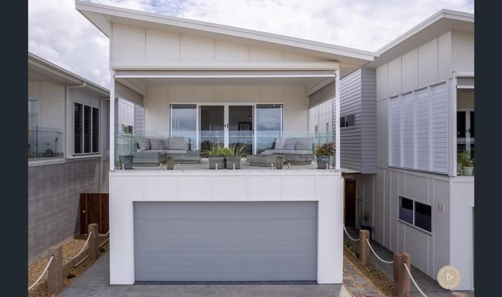 a large white house with a large garage at Salt Zen Holiday Townhouse in Agnes Water