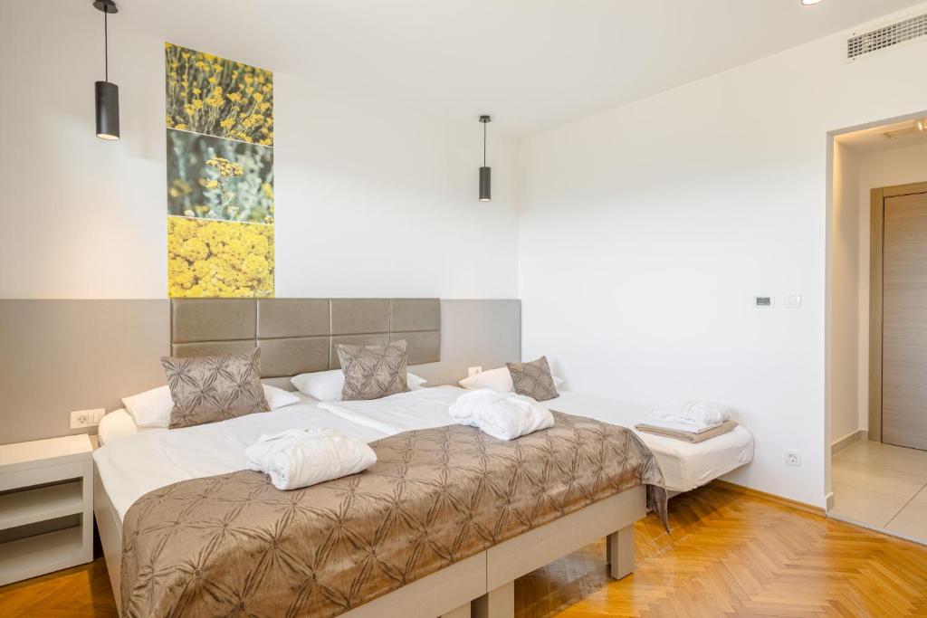 a large bed with two pillows on it in a room at Rogač Rooms & Restaurant in Omiš