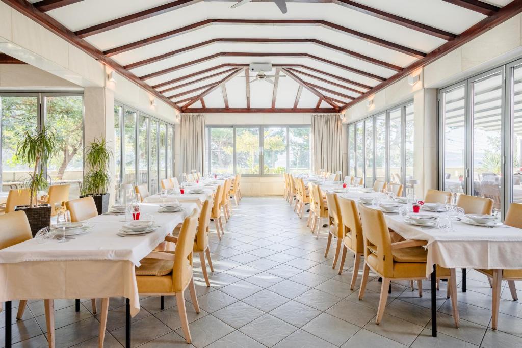a row of tables in a room with windows at Rogač Rooms & Restaurant in Omiš
