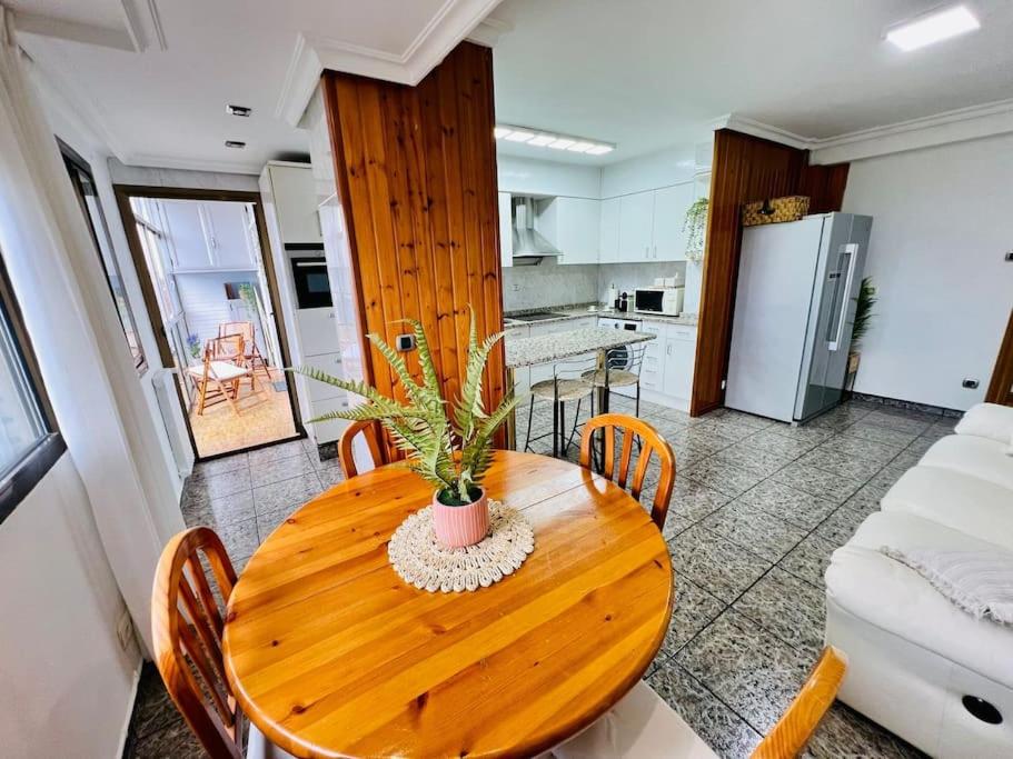 a kitchen with a wooden table with chairs and a dining room at A Orillas del Pilar con parking in Zaragoza