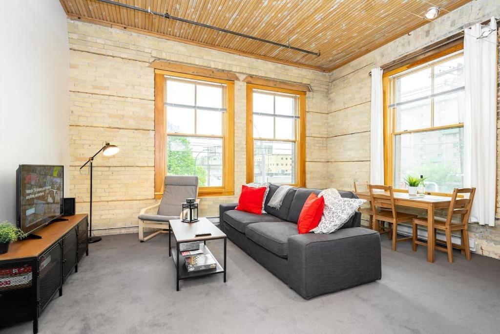 sala de estar con sofá y mesa en New York Style Loft with Parking Exchange District Coffee Gym en Winnipeg