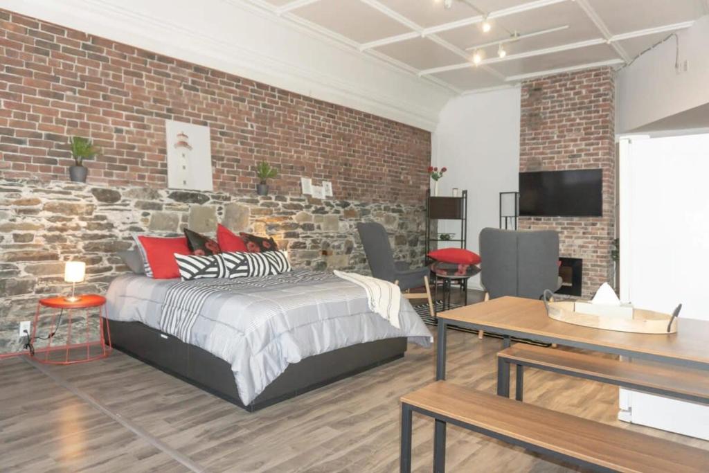 een slaapkamer met een bed en een bakstenen muur bij Cozy Studio In the Heart Uptown Saint John! Parking Coffee in Saint John