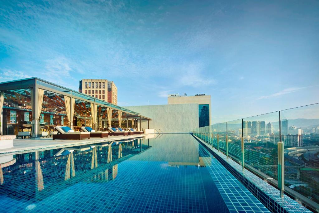 a swimming pool on the roof of a building at Hotel Stripes Kuala Lumpur, Autograph Collection in Kuala Lumpur