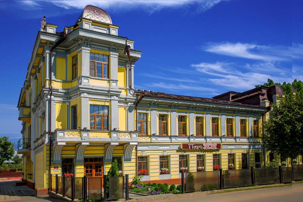 um edifício amarelo com uma torre em cima dele em Selivanov Hotel em Rostov