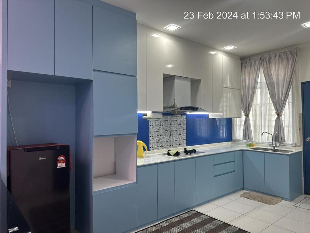 a blue and white kitchen with a sink and a refrigerator at ML Homestay in Kampung Seelung