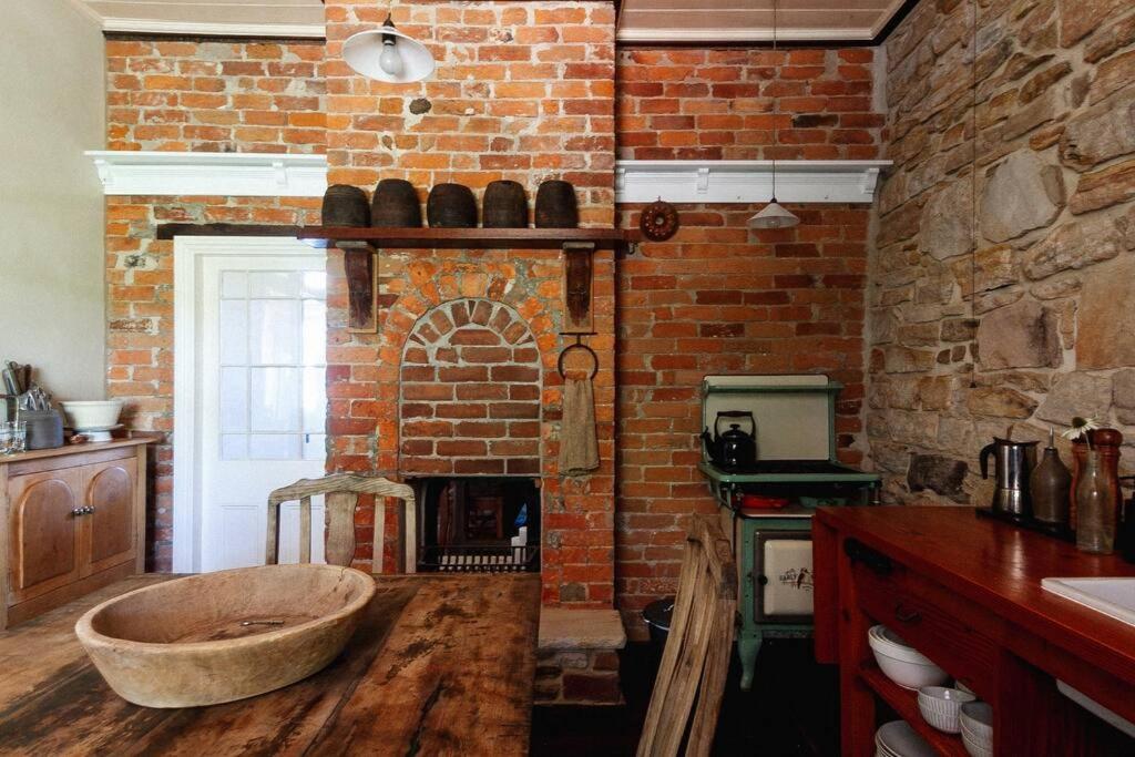 eine Küche mit einem gemauerten Kamin und einer großen Holzbadewanne in der Unterkunft The Old Clarence Brewery in Maclean