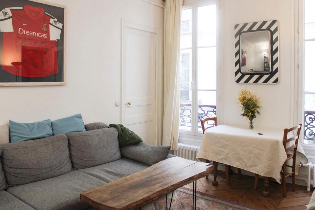 een woonkamer met een bank en een tafel bij Spacious apartment - near Palais Garnier in Parijs