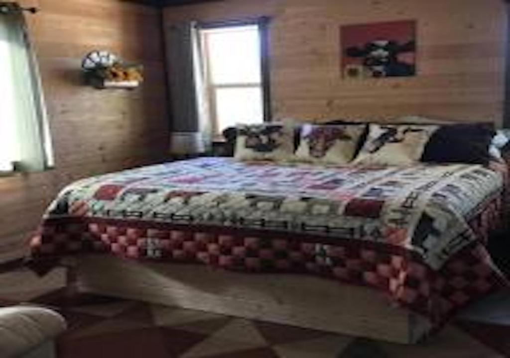 une chambre avec un lit avec une couette dessus dans l'établissement Farm House Cabin, Patio, TV Room, Games, BBQ, Campfire, à Verdure