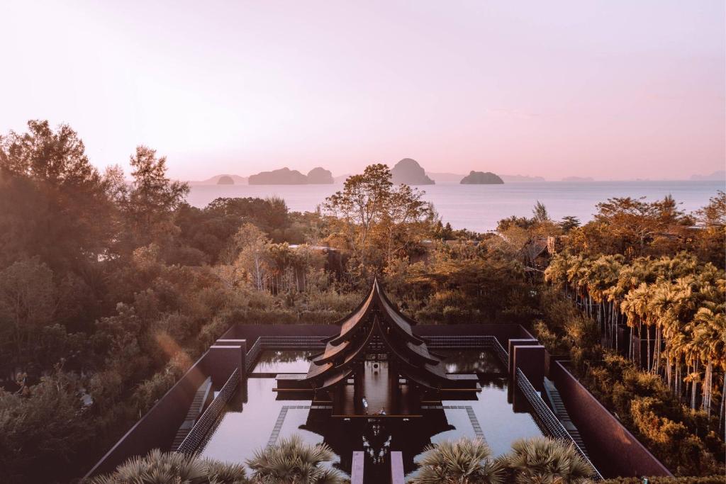 a temple in the middle of a forest with the ocean at Phulay Bay, A Ritz-Carlton Reserve in Tab Kaek Beach