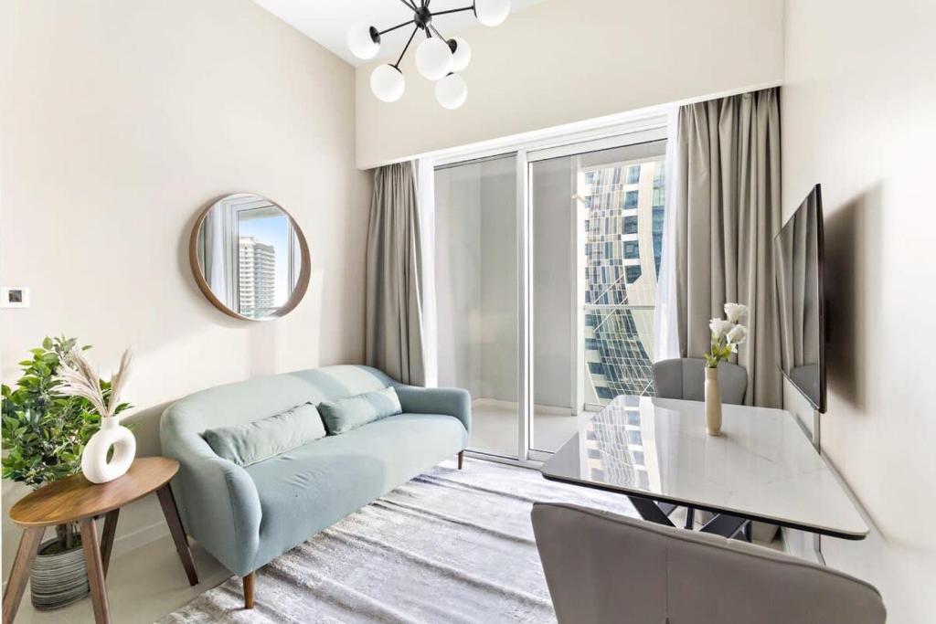 ein Wohnzimmer mit einem blauen Sofa und einem Tisch in der Unterkunft Silkhaus Business Bay in new Building Large studio with bedroom in Dubai