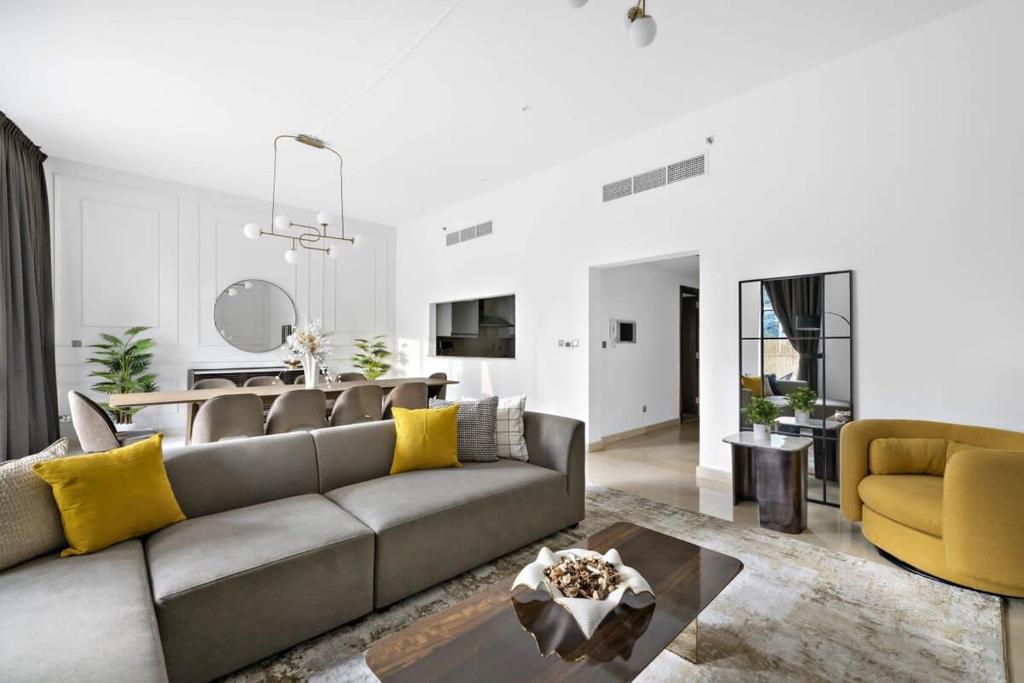 a living room with a gray couch and yellow pillows at Silkhaus Ideal for Big Family, 5BDR with Private Roof Top in Dubai