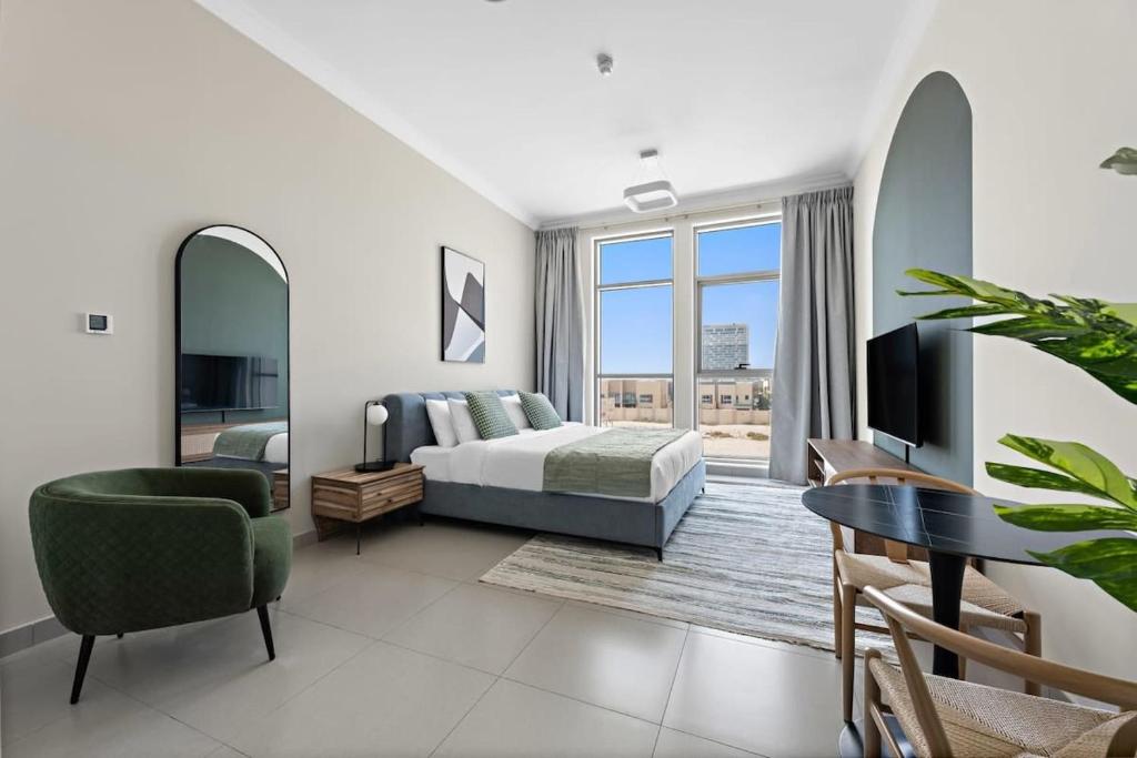 a bedroom with a bed and a tv and a table at Chic Studio in Art Gardens Modern Living in Dubai