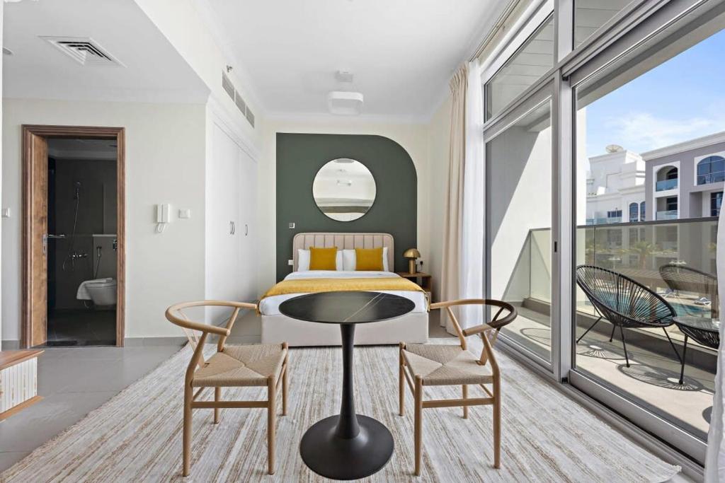 - une chambre avec un lit, deux chaises et une table dans l'établissement Silkhaus modern studio in Art Gardens in-house kitchen, à Dubaï