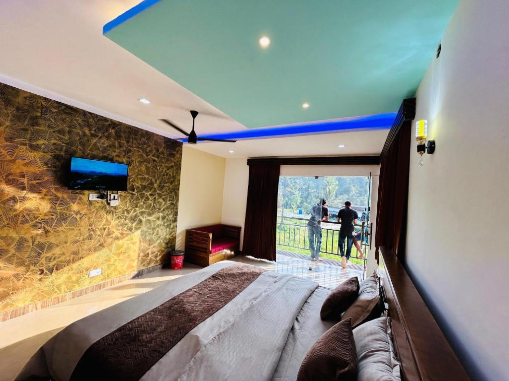 a bedroom with a large bed and a tv on a wall at Greenview in Vythiri