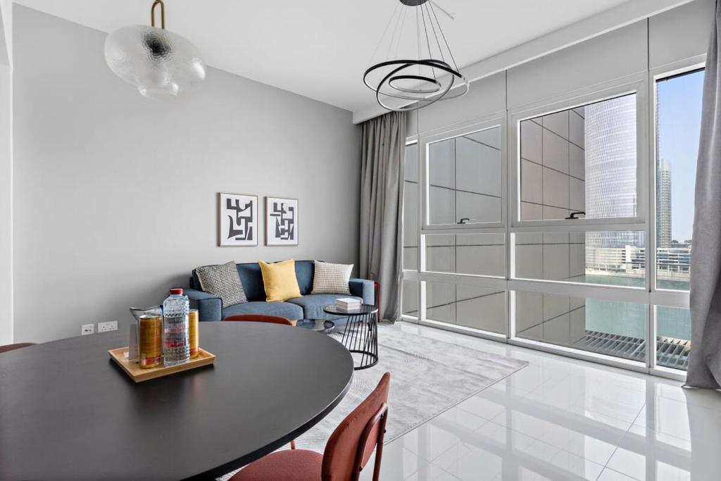 a living room with a table and a couch at Silkhaus Spacious 1 BDR Al Fay Park Nearby in Abu Dhabi