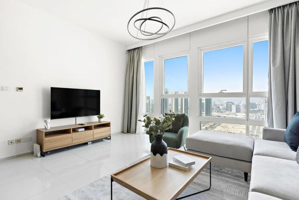 a living room with a couch and a tv at Silkhaus Modern 1 BDR Al Fay Park Nearby in Abu Dhabi