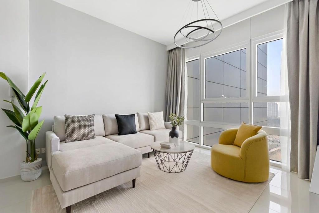 uma sala de estar com um sofá e uma cadeira em Silkhaus New 1 BDR Al Fay Park Nearby em Abu Dhabi