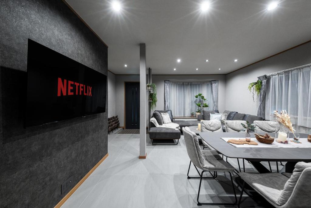 sala de estar con TV, mesa y sillas en THE CITYSCAPE en Kita-sanjō