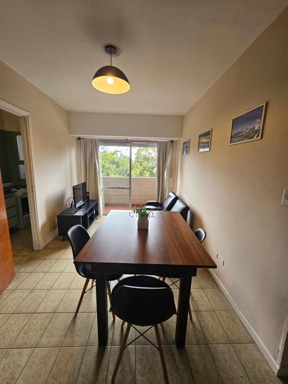 a living room with a wooden table and chairs at 3 Ambientes frente al Golf - Playa Grande in Mar del Plata