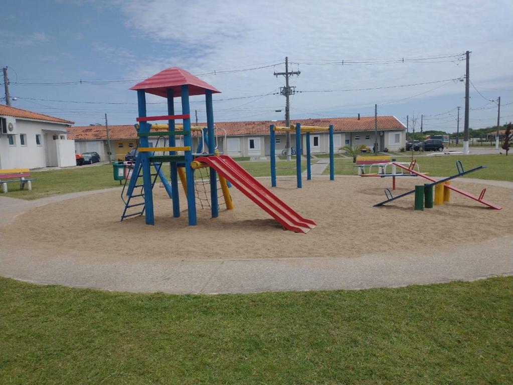 einen Spielplatz mit Rutsche im Sand in der Unterkunft Casa em Condomínio Fechado in Pelotas