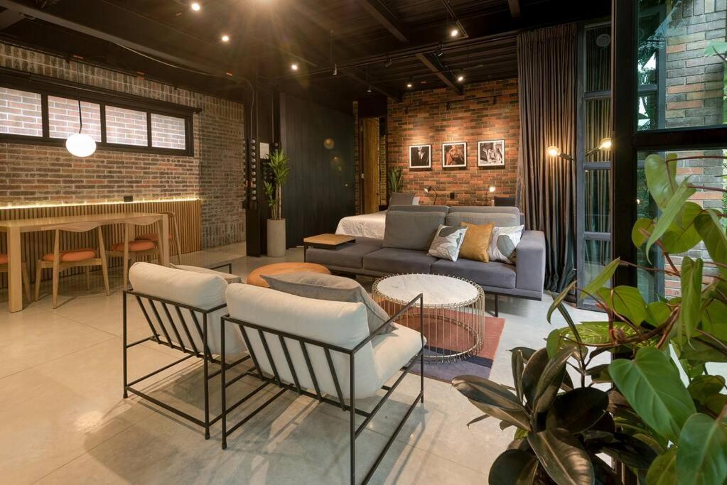 sala de estar con sofá, mesa y sillas en Hotel Meridiano Lofts, en Medellín