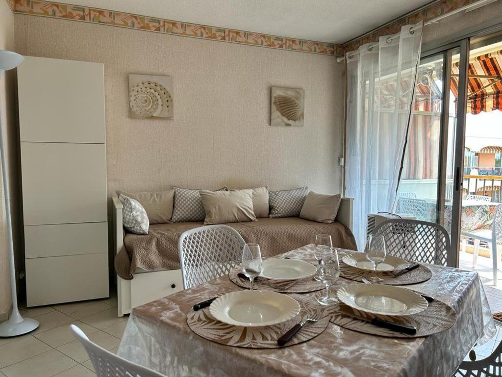 ein Wohnzimmer mit einem Tisch und einem Sofa in der Unterkunft Appartement Mandelieu-la-Napoule, 1 pièce, 3 personnes - FR-1-609-96 in Mandelieu-la-Napoule