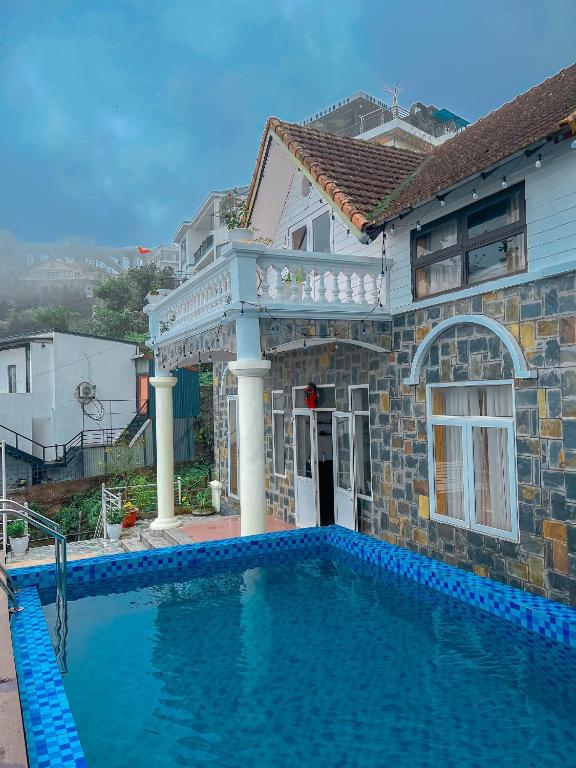 a house with a swimming pool in front of a house at Villa Đường Mây 2 in Tam Ðảo