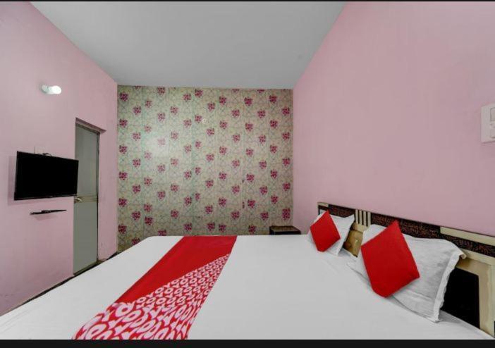 ein Schlafzimmer mit einem großen Bett mit roten Kissen in der Unterkunft H R Palace in Dīgha