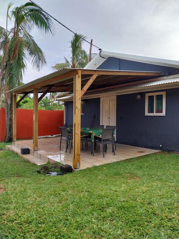 een pergola met een tafeltennistafel op een patio bij Case Lénaron in Saint-Joseph