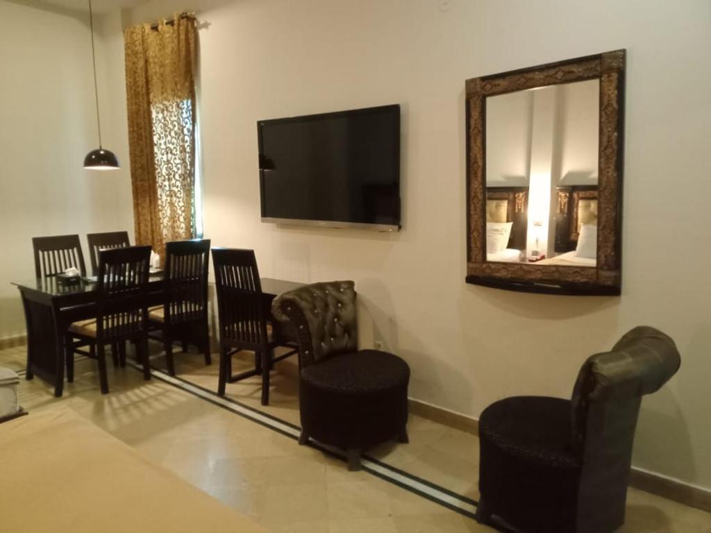 a dining room with a table and chairs and a mirror at Lotus 1 Hotel in Lahore