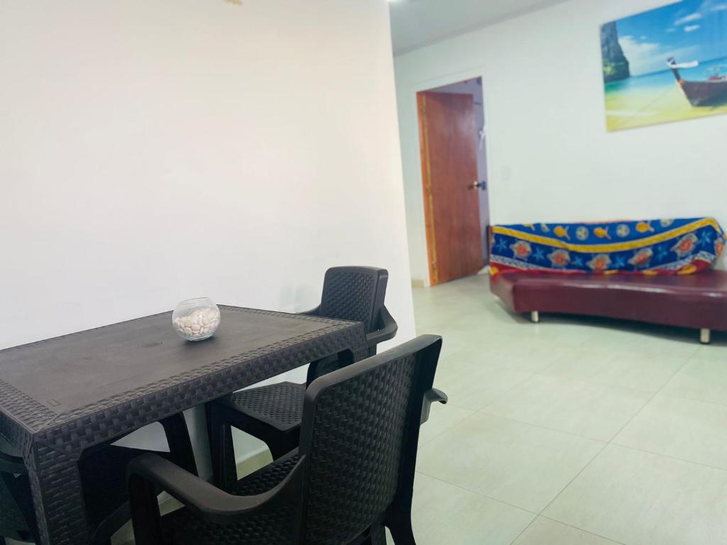 einen Tisch und Stühle in einem Zimmer mit Sofa in der Unterkunft Apartamentos ZION cerca a la playa SAI in San Andrés