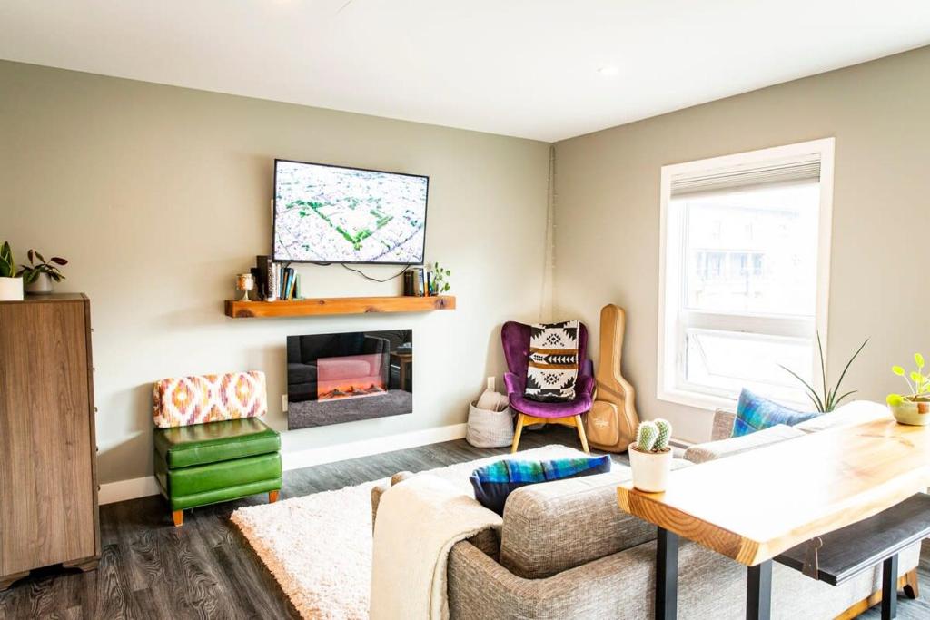 a living room with a couch and a tv at Suite Lines Revy - One Bedroom Near RMR in Revelstoke