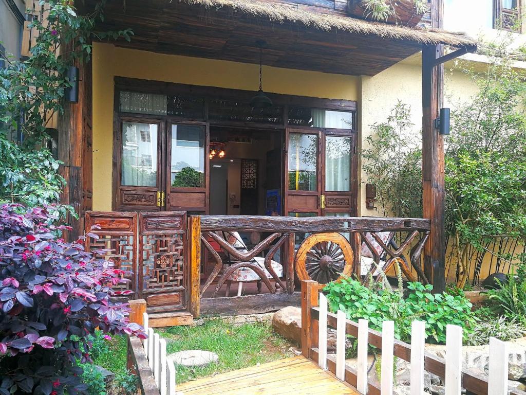 Old Story Inn Lijiang Old Town في ليجيانغ: منزل به بوابة خشبية وشرفة