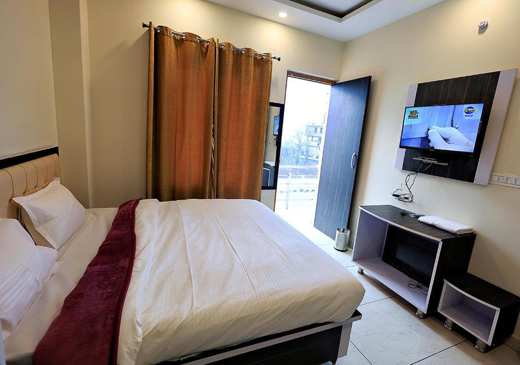 Schlafzimmer mit einem Bett und einem Flachbild-TV in der Unterkunft Knights' Inn in Shamshi