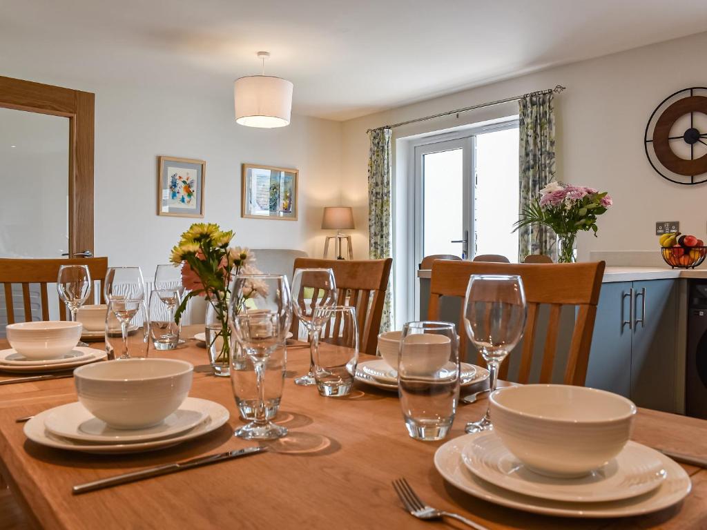 a dining room table with plates and glasses on it at Burrows Ridge in Appledore