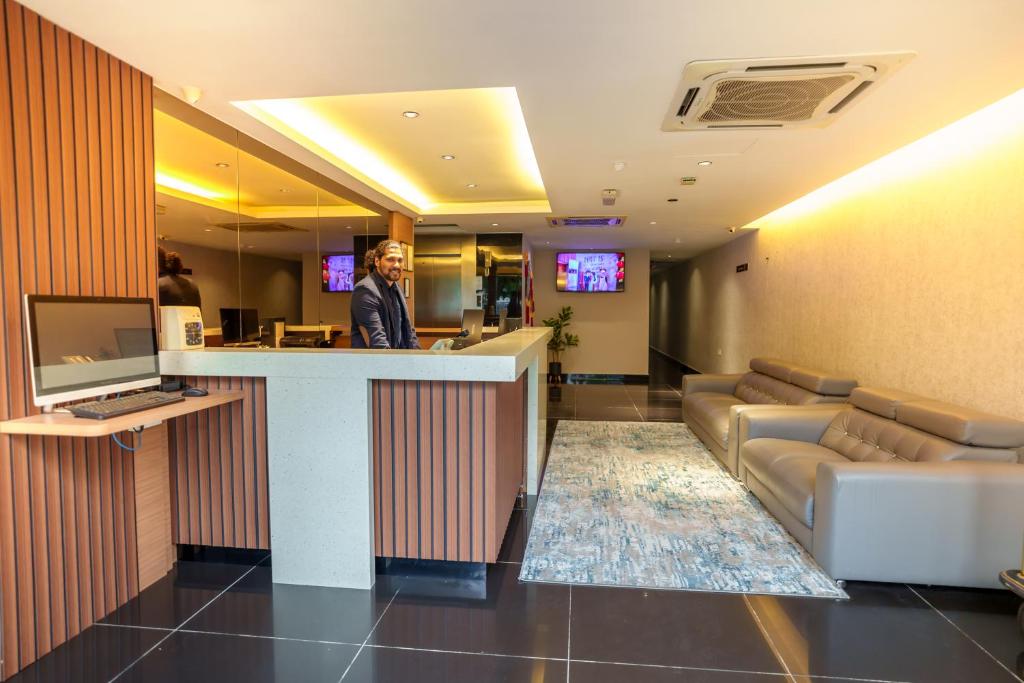a man standing at a bar in a hotel lobby at Euro Life Hotel @ KL Sentral in Kuala Lumpur