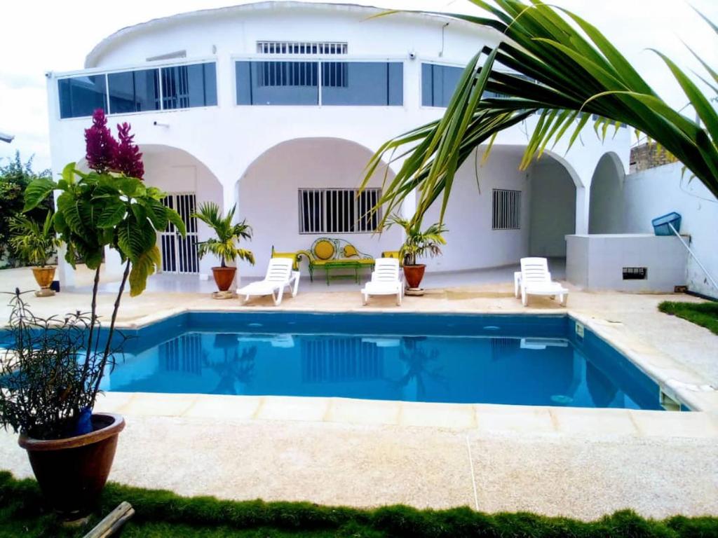 eine Villa mit Swimmingpool und ein Haus in der Unterkunft Keur Fatou in Ngaparou