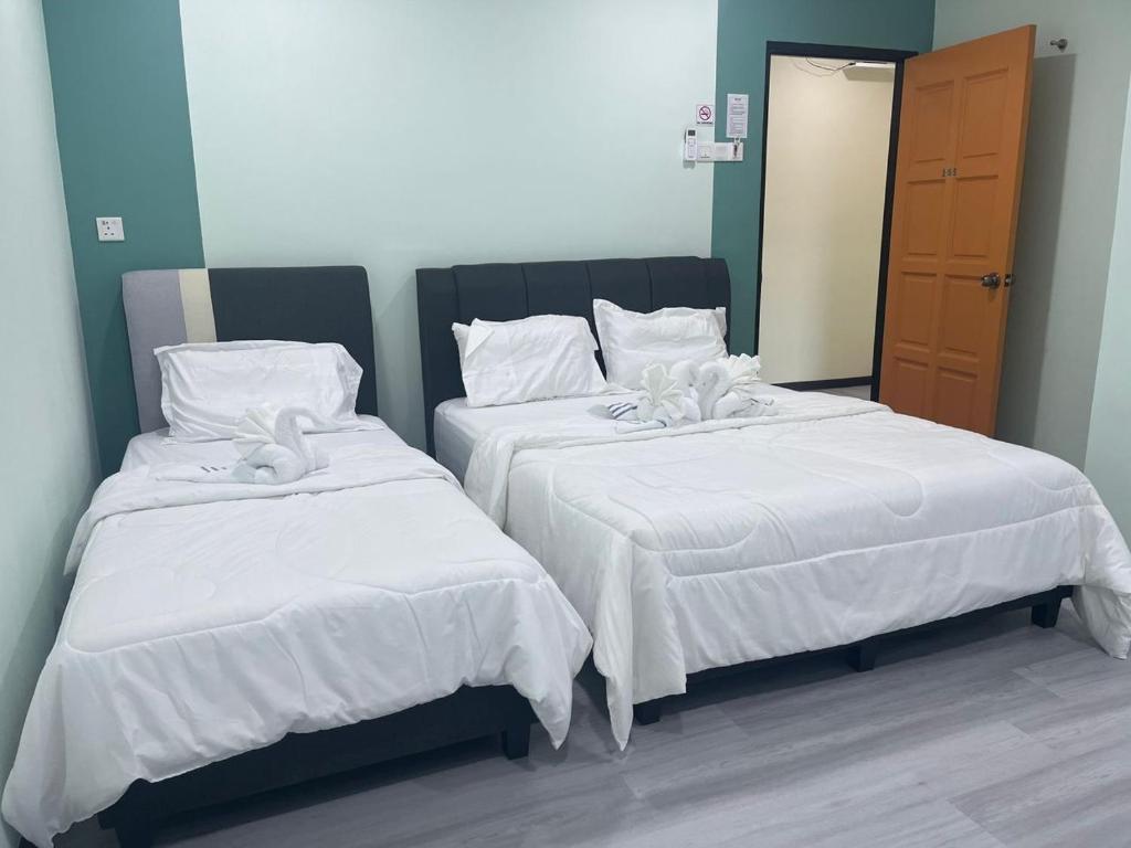duas camas com lençóis brancos num quarto em Good Night BD Motel 