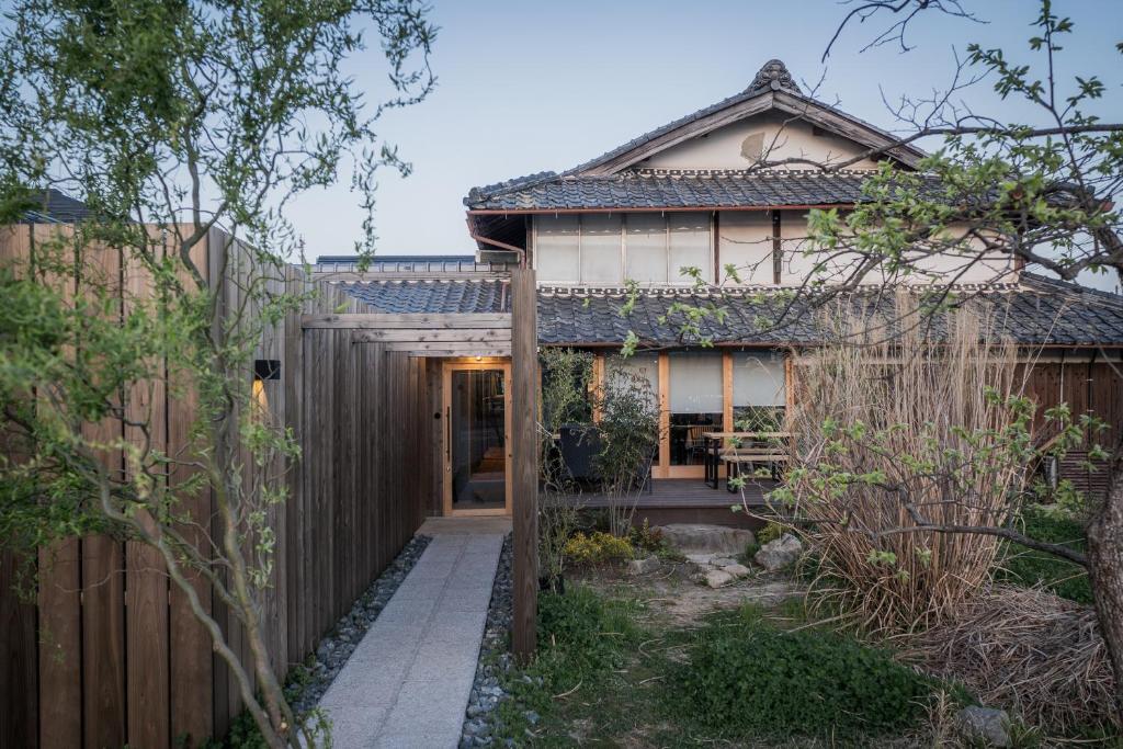 a home with a wooden fence and a house at 6ishiki in Kameoka
