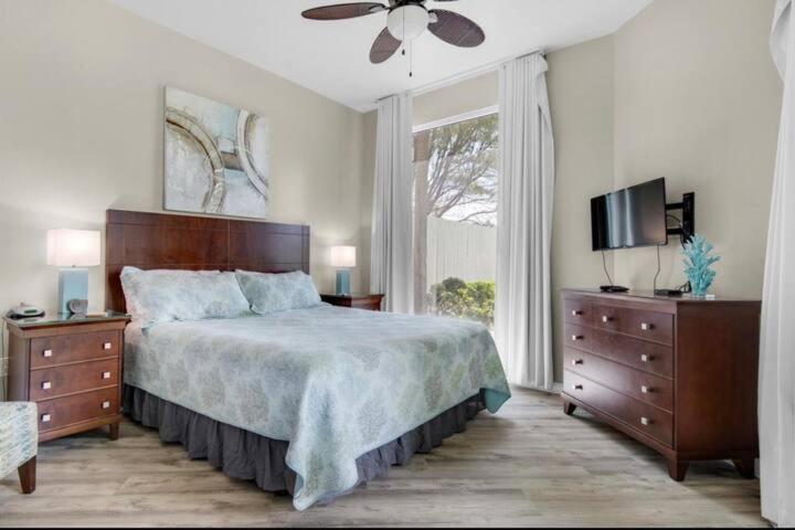 ein Schlafzimmer mit einem Bett, einem Fernseher und einem Fenster in der Unterkunft The Palms of Destin-2116 in Destin